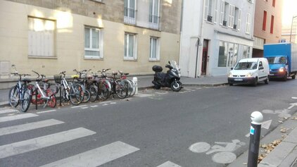 Photo d'un parking vélo devant un passage piéton.
